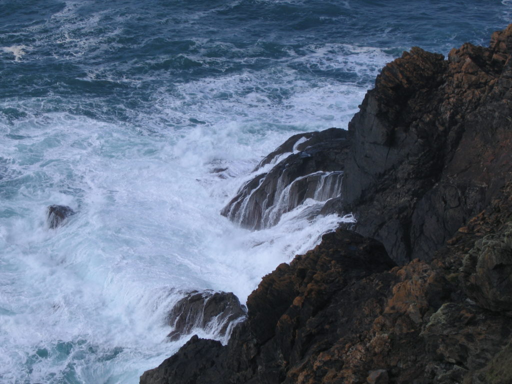 A photo of waves crashing into cliffs