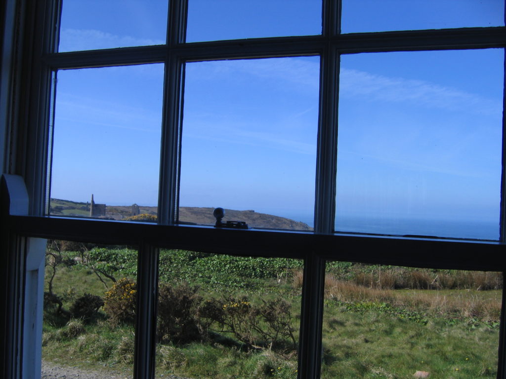 Blue sky and sea, green grass as seen through a window, colour photo, Cornwall
