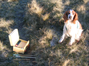 dog sitting beside painter's box